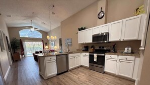 A kitchen with white cabinets, a microwave, an oven, and a dishwasher. - Private Pool Villa, Many Updates! Southern Dunes (Haines City)