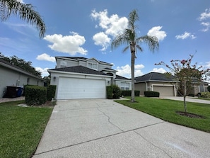 A residential house with a garage, a driveway, and a well-maintained lawn. - Beautifully Remodeled Home - Southen Dunes Golf Course Views (Haines City)