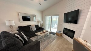 A modern living room with a sofa, coffee table, and fireplace.