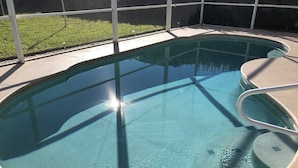Une piscine ovale aux contours nets, avec un niveau d’eau clairement visible et une échelle en métal.