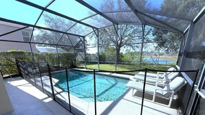 Ein überdachter Pool im Freien mit Liegestühlen und Blick auf die umliegende Landschaft.