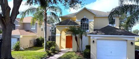 A two-story house with a garage, a front entrance, and a well-maintained lawn.