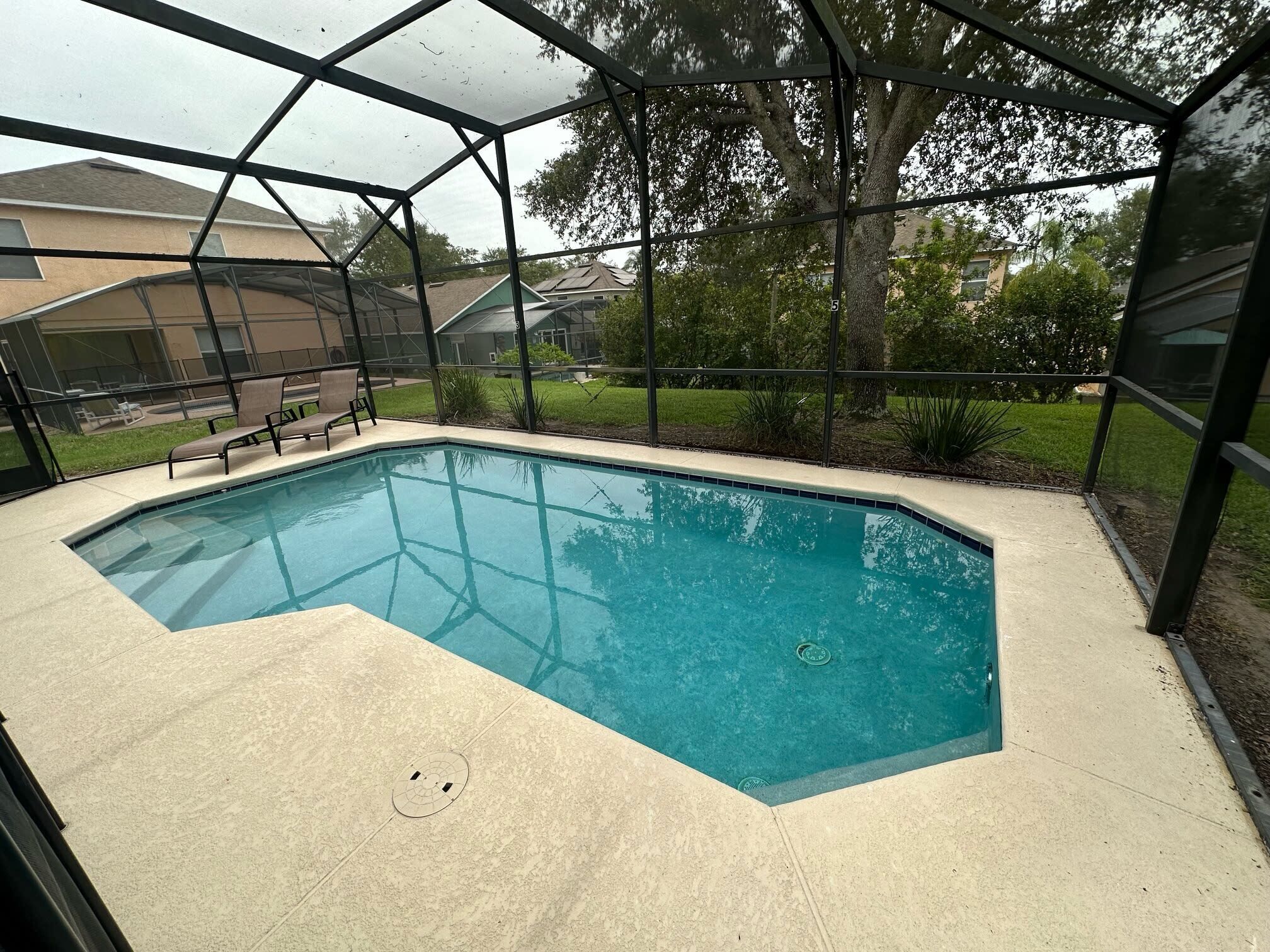 A covered outdoor swimming pool with a clear view of the surrounding neighborhood.