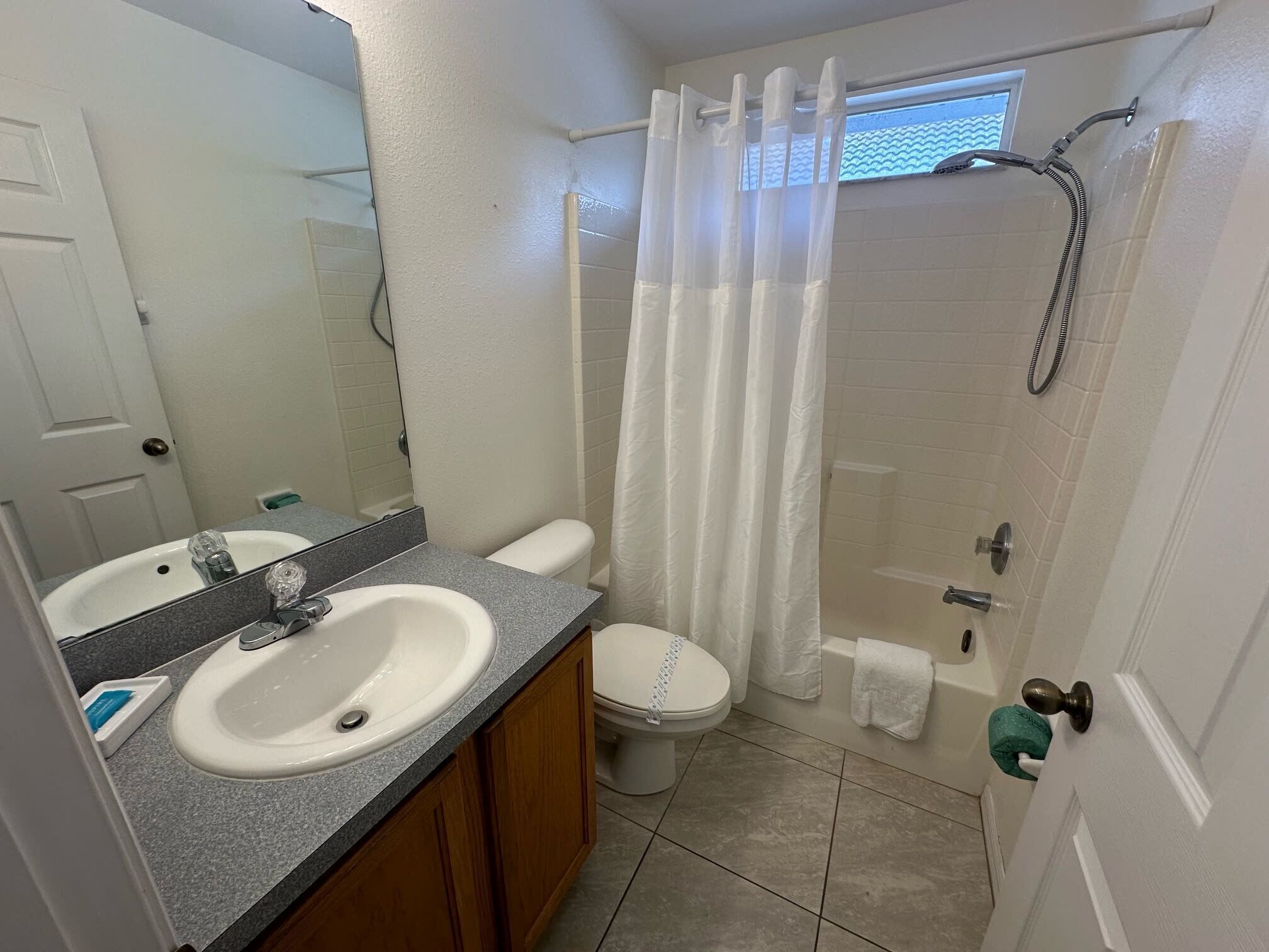 A bathroom with a sink, toilet, and shower area.