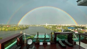 A rooftop terrace with a view of a river and a rainbow. - Luxurious Penthouse for Rent Bucharest - Marque De Lago (București)