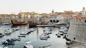 A harbor with numerous boats docked, historic buildings, and a prominent castle-like structure. - Charming 2-bedroom apartment with WiFi, AC in lovely Dubrovnik (Dubrovnik)