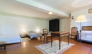 Ein Zimmer mit zwei Betten, einem Esstisch und einem Stuhl.