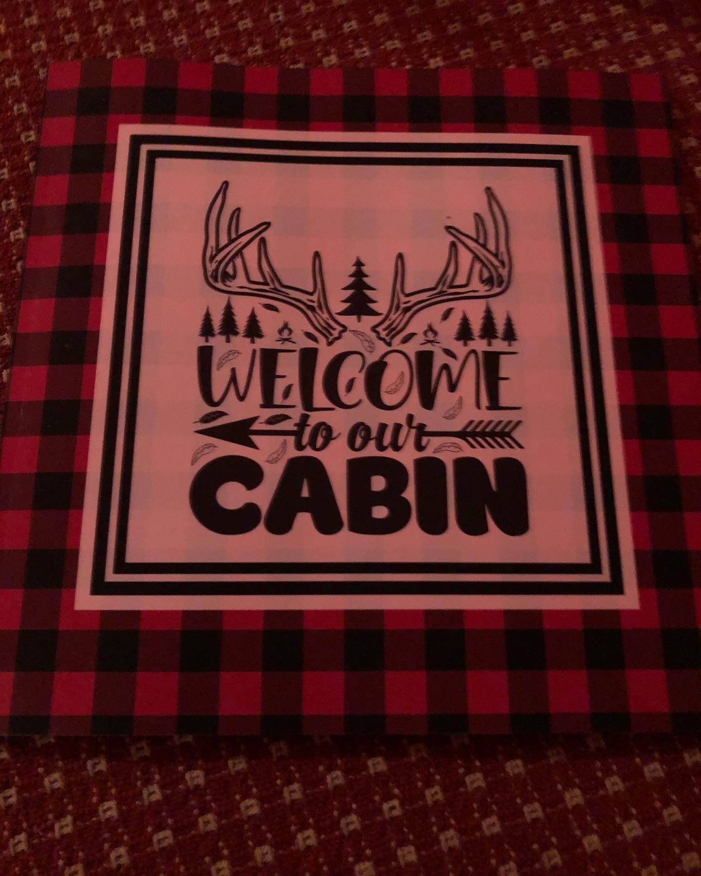 A welcome sign with antlers and trees, indicating a cabin setting.