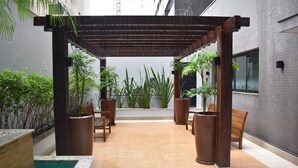 A covered outdoor area with a pool, seating, and potted plants. - Studio near Botanical Garden (Cristo Rei Curitiba)