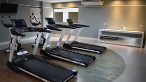 A gym with treadmills, a digital display, and a bench. - Studio near Botanical Garden (Cristo Rei Curitiba)