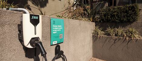 An electric vehicle charging station with a sign in a foreign language.