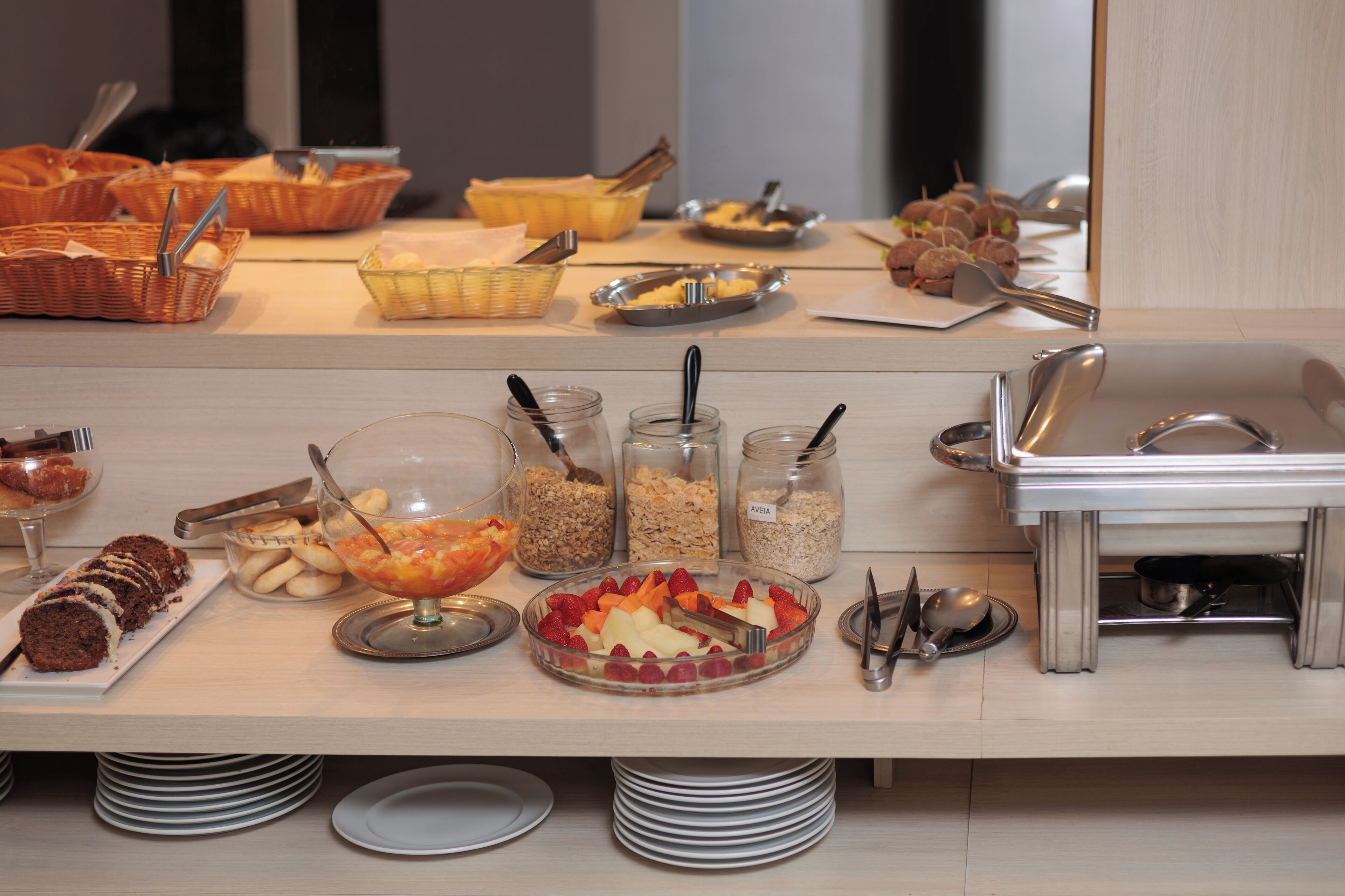 A buffet table with various food items and serving utensils.