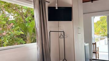 Un dormitorio moderno con una cama grande, un televisor de pantalla plana en la pared y vistas a zonas verdes.