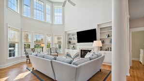 A spacious living room with a large sofa, a fireplace, and a television.