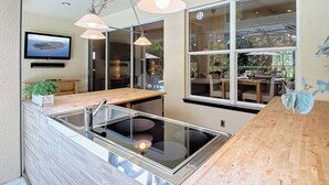 Eine moderne Küche mit großem Fenster, Pendelleuchten und einer eingebauten Spüle.