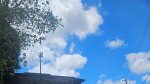 Un bâtiment à deux étages, doté d’une entrée fermée par un portail, d’une clôture blanche et surplombant un ciel dégagé.