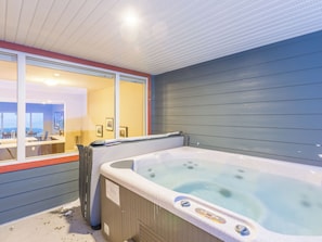 Un baño con jacuzzi, una ventana y un espejo.