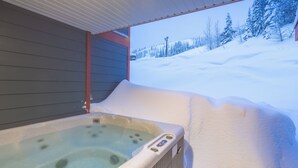 Ein Whirlpool mit Blick auf verschneite Landschaft.