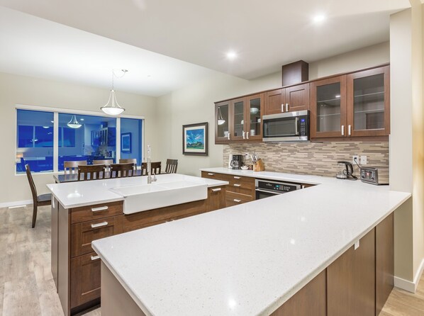 Una cocina moderna con una isla grande, armarios de madera y vistas al área de comedor.