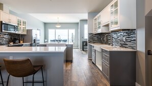 A modern kitchen with a central island, built-in appliances, and a view to the outdoors.