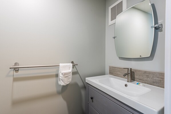 A bathroom with a white sink, a mirror, and a towel rack. - Bright & Cozy 3-Bedroom Townhome w/ Ski-In/Ski-Out & Hot Tub (Vernon)