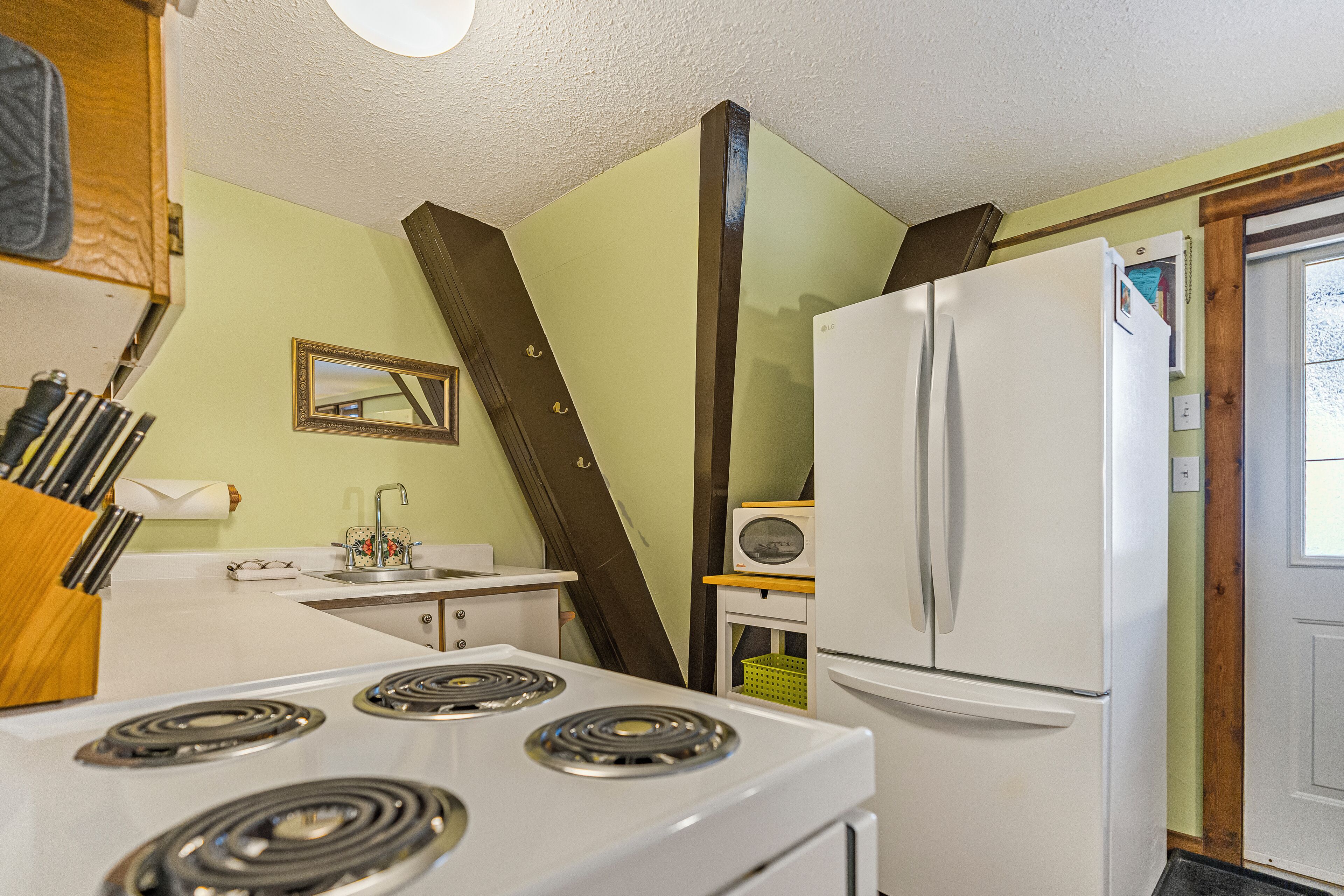A kitchen with a stove, refrigerator, and sink.