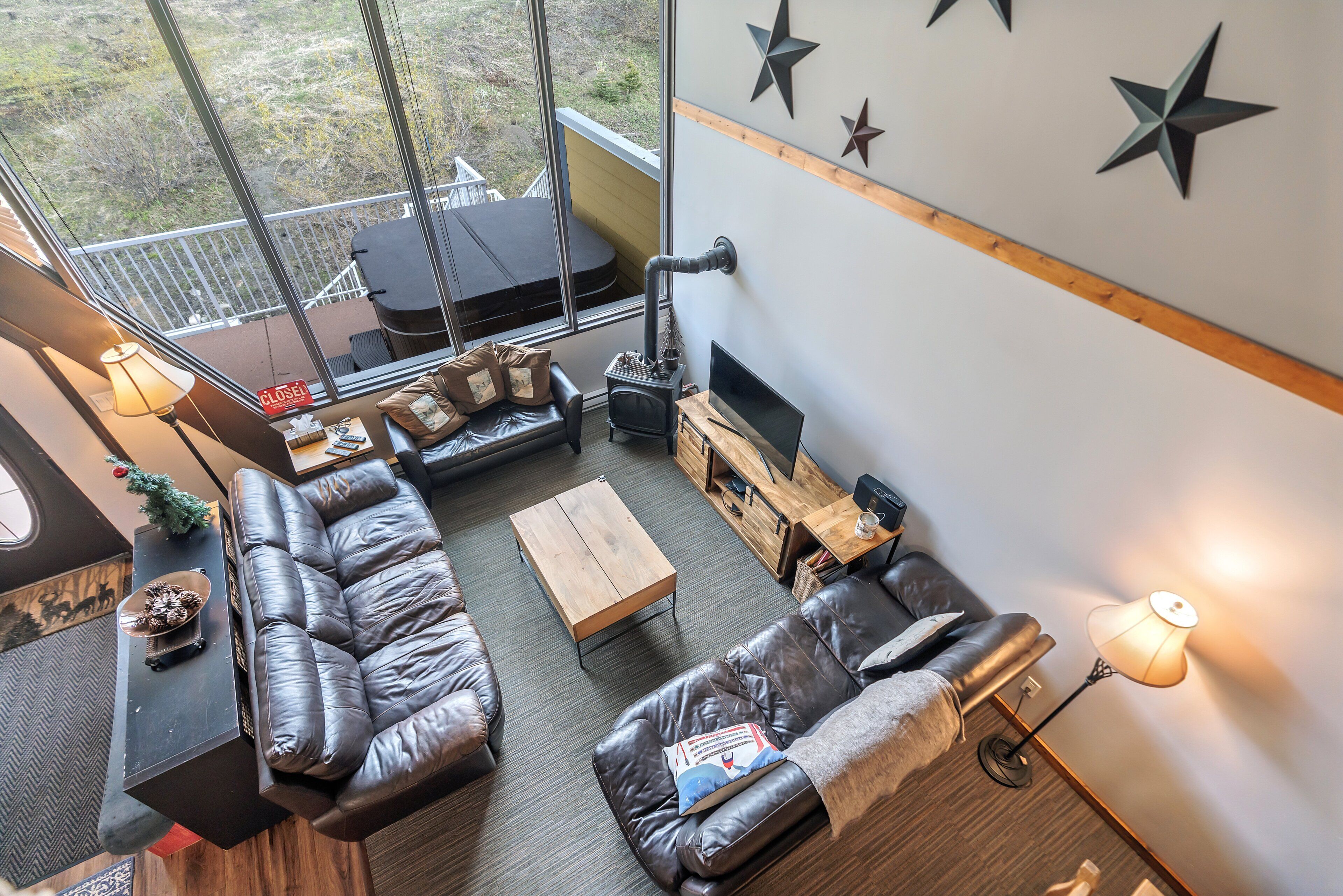 Ein Wohnzimmer mit Ledersofas, einem Holztisch, einem Kamin und einem Fernseher.