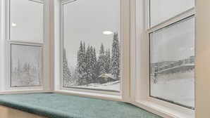 A bay window with three framed pictures depicting snowy landscapes.