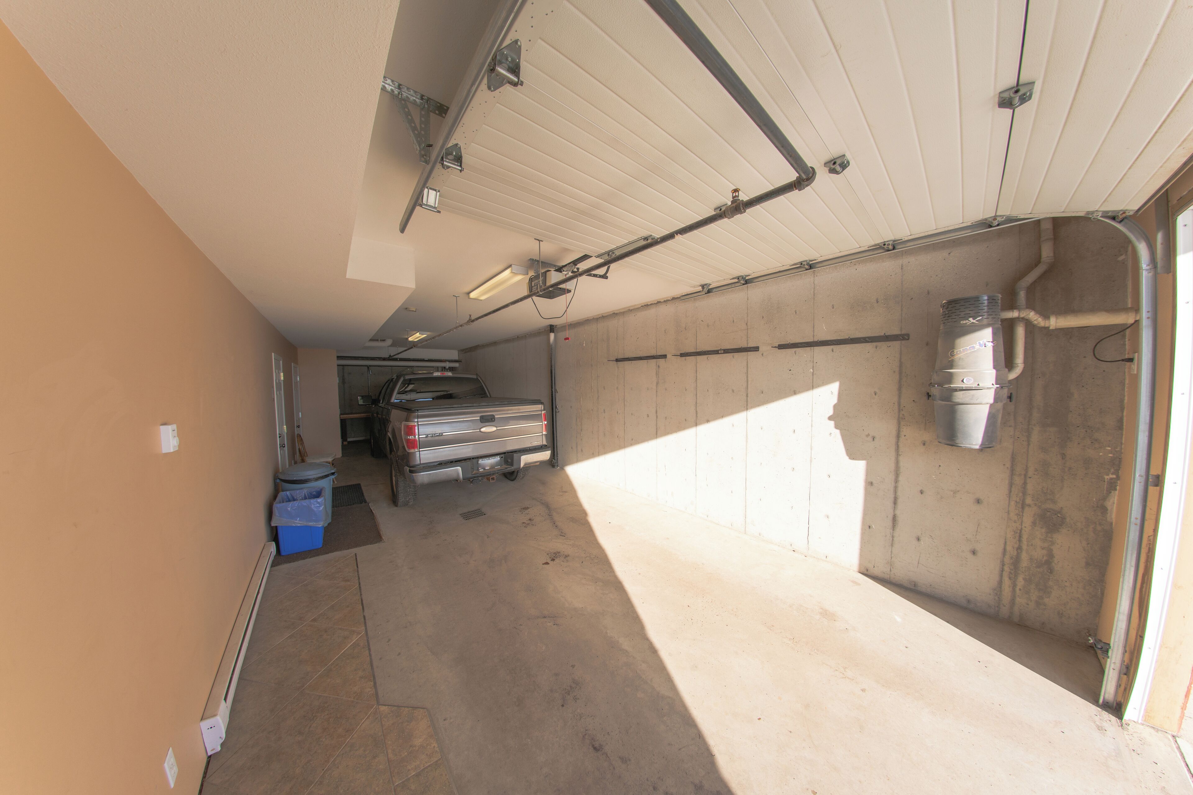 A garage with a truck, a workbench, and a water heater.