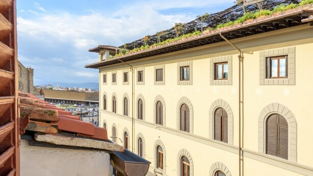 A multi-story building with arched windows and a flat roof.