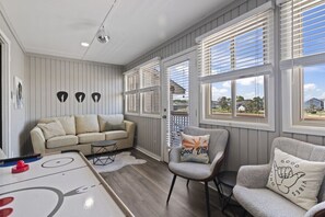 Uma sala de estar aconchegante com sofá, poltronas, mesa de centro e mesa de boliche.