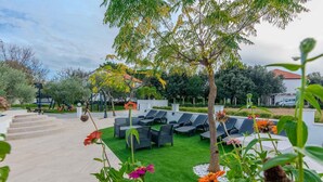 A patio area with outdoor seating and a small tree. - Stunning apartment in Zaton (Zaton)