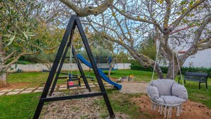 A playground with a swing set, slide, and a hanging chair. - Stunning apartment in Zaton (Zaton)