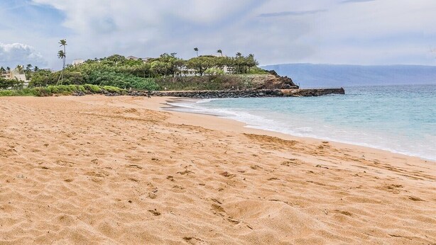 A beach with a rocky outcrop and a building on a small island. - Luxurious and Spacious 2BD Kaanapali Condo (Lahaina)