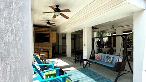 A covered outdoor seating area with blue chairs, a swing, and a ceiling fan. - 3-bedroom, 2.5-bathroom, sleeps 10 people with heated pool and elevator. (Murrells Inlet)