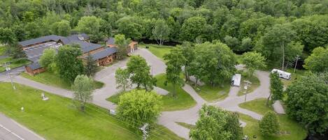 A campground with RV parking, a lodge building, and a river.