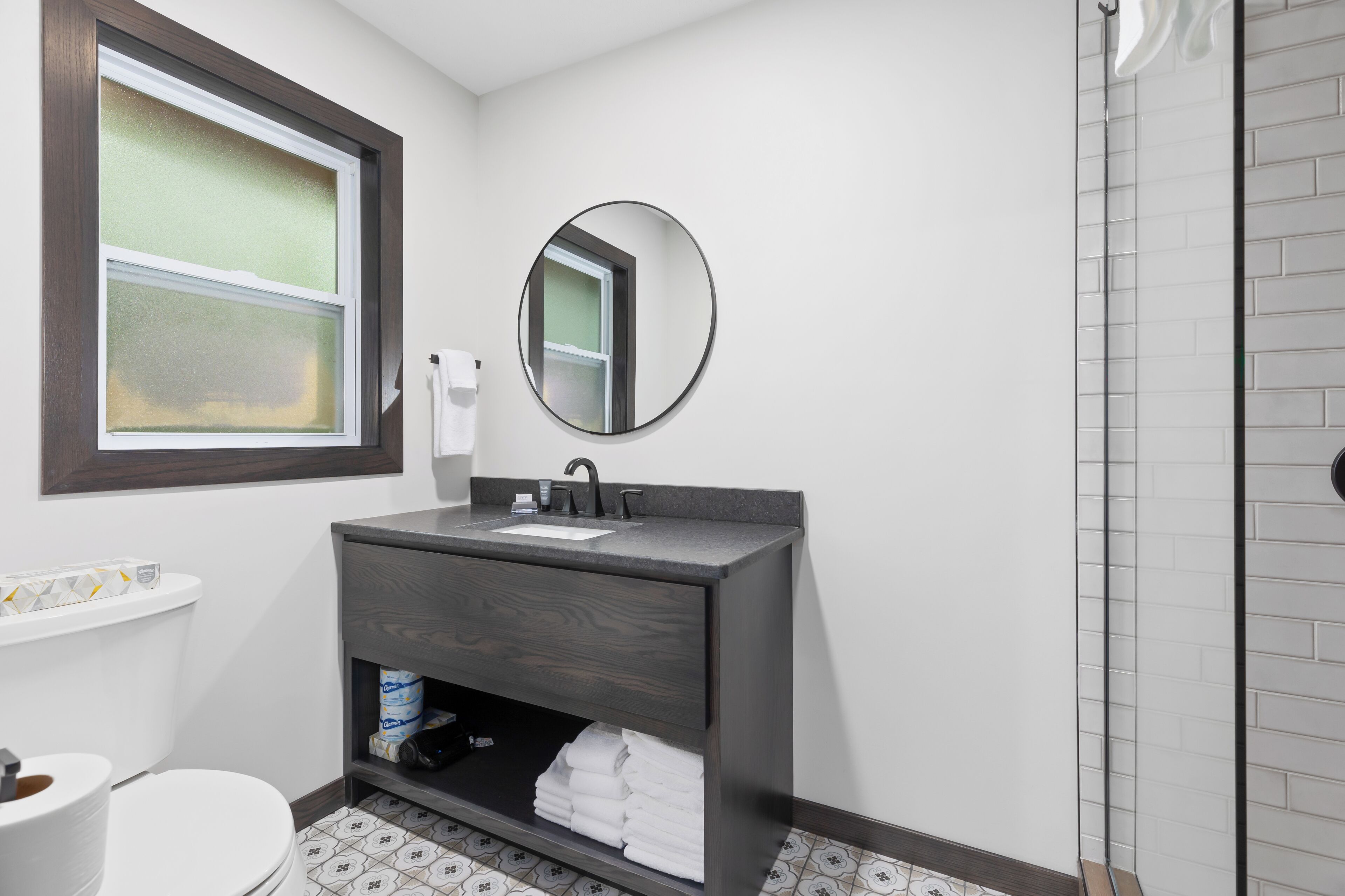 A bathroom with a toilet, sink, and shower.
