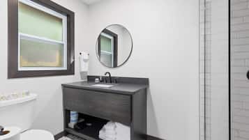 A bathroom with a toilet, sink, and shower.