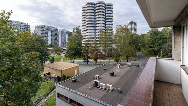A high-rise building with a modern design, surrounded by trees and a parking area. - Park Śląski Comfy Apartment (Katowice)