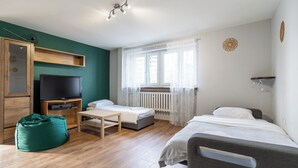 A room with a bed, a desk, a television, and a bean bag chair. - Park Śląski Comfy Apartment (Katowice)