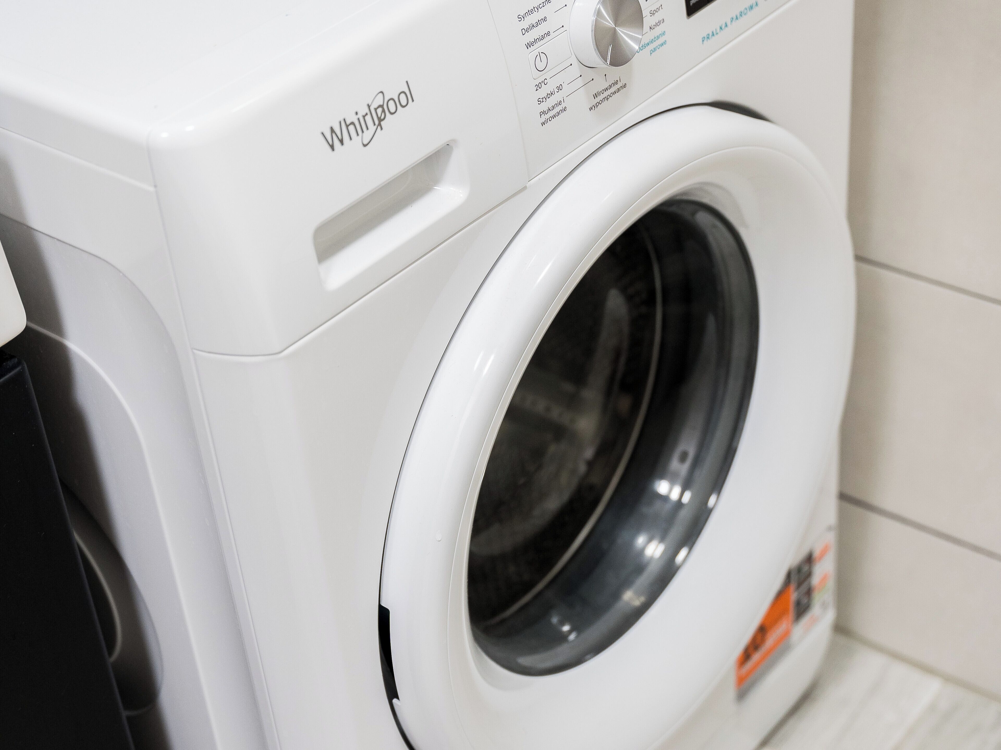 A Whirlpool washing machine with a control panel displaying temperature settings and cycle options.