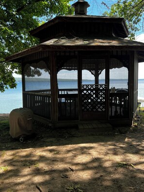 A wooden gazebo with a lattice railing, overlooking a body of water. - CozyStudio sitting on 2.5 acres on Hubbard Lake with WiFi, AC (Hubbard Lake)