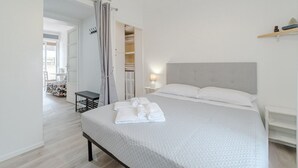 A bedroom with a bed, a bedside table, a nightstand, a wardrobe, and a view of a balcony. - GuestHost - Cosy flat with a view of the Mole Antonelliana for 3 people, located on the 5th floor of a period building (WITH LIFT). The building is located in the historic centre of Turin, a few minutes on foot from the Mole Antonelliana and the Egyptian (Torino)