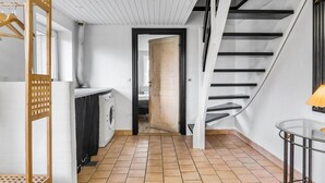 A modern kitchen with a built-in washing machine, a wooden cabinet, and a staircase leading to an upper level. - Awesome home in øster assels with WiFi (Øster Assels)