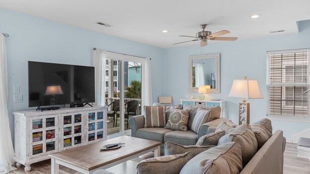 A living room with a TV, sofa, coffee table, and a cabinet with storage boxes. - Island Girl-Beautiful 4BD Ocean View-Private Pool-Pet Friendly (Surfside Beach)