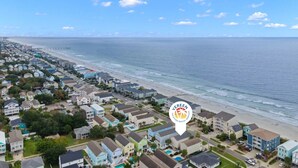 A coastal residential area with a beachfront, houses, and a pier in the distance. - Island Girl-Beautiful 4BD Ocean View-Private Pool-Pet Friendly (Surfside Beach)