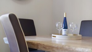 Et spisebord med en vinflaske og to glas på et fad.