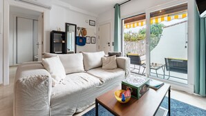 A living room with a sofa, a coffee table, and a view of the outside. - Apartment 'Mi Patio, Port Of Cabopino' with Shared Pool, Wi-Fi and Air Conditioning (Unknown)