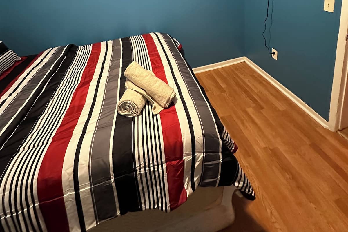 A room with a bed, a wall-mounted TV, and two circular wall decorations.