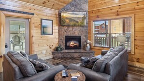 Een knus interieur van een chalet met een stenen openhaard, houten wanden en een comfortabele zithoek.